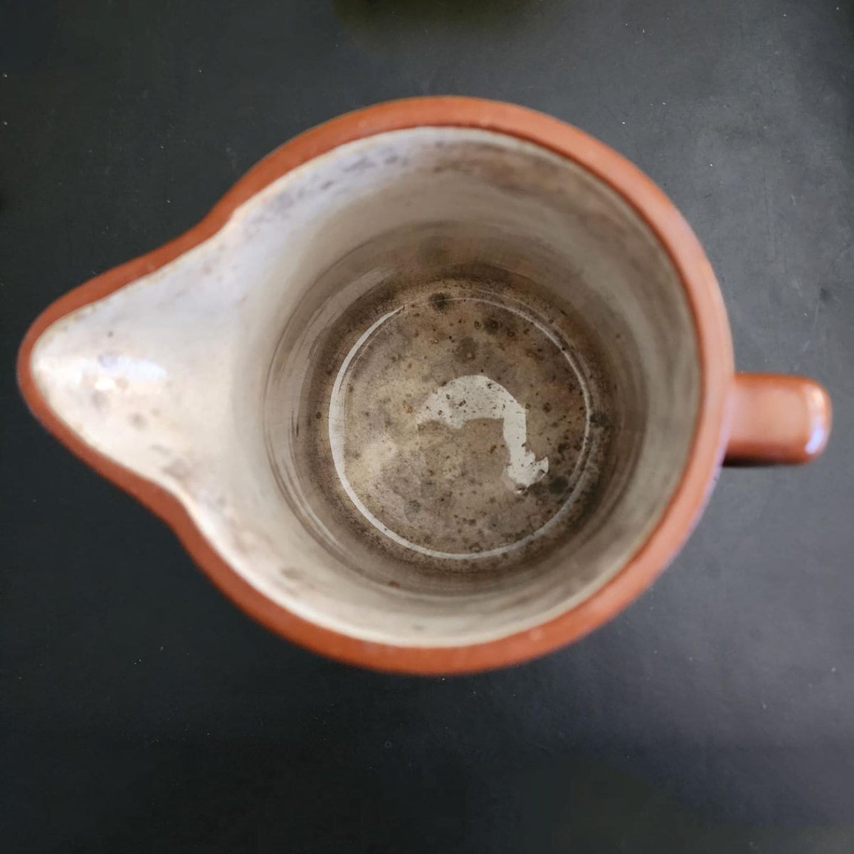 A brown jug with a handle on a white background.